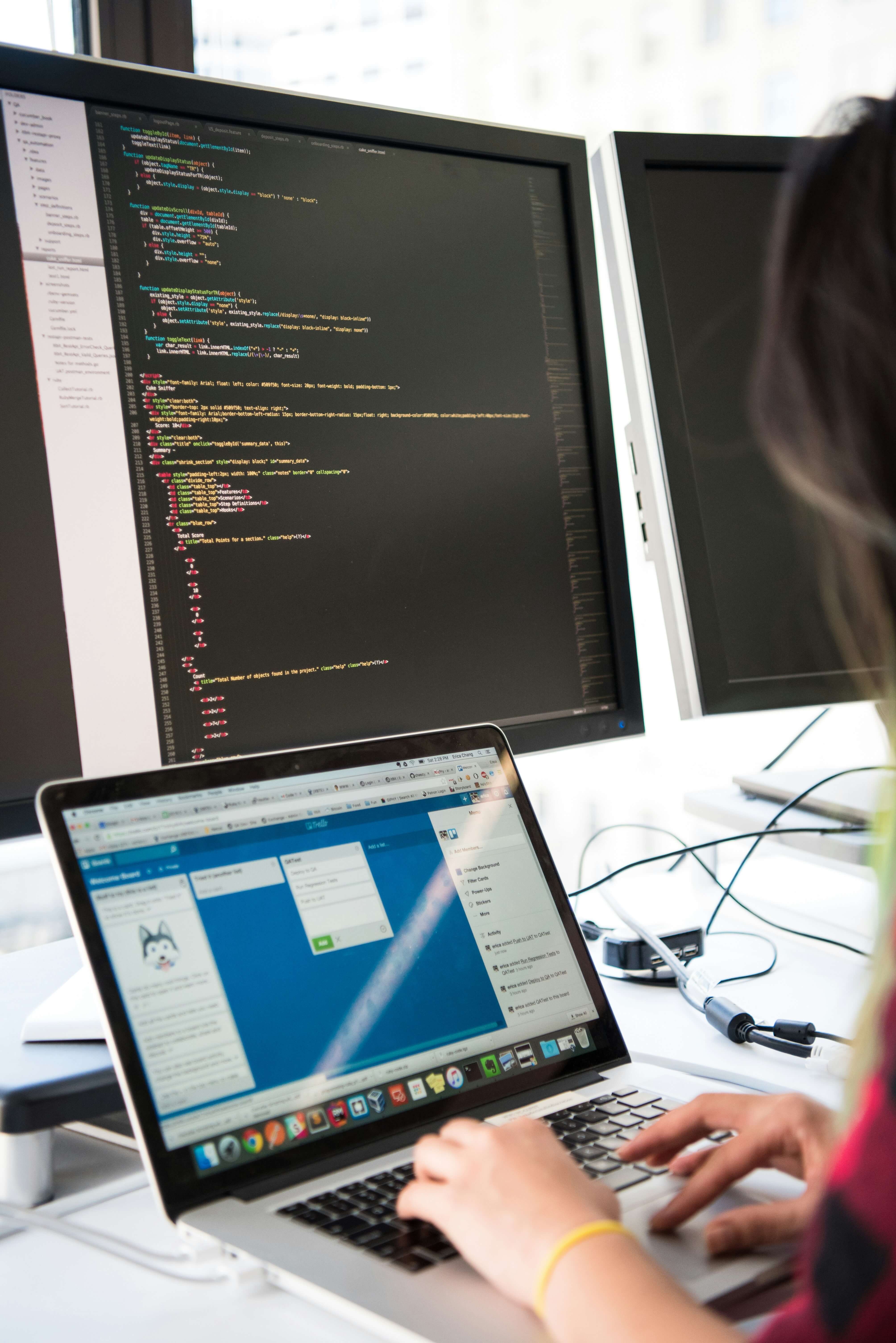 Software developer working at multi-screen workstation